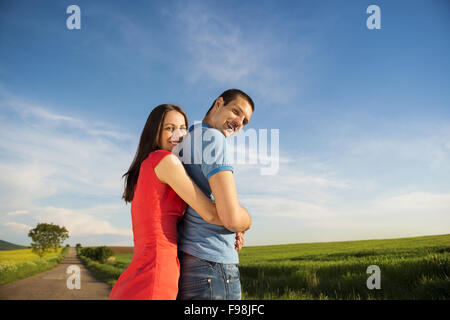 Glückliches junges Paar in Liebe umarmt unterwegs Landschaft neben dem Raps Feld Stockfoto