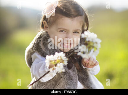 Outdoor Portrait der niedliche kleine Mädchen mit blühender Zweig Stockfoto