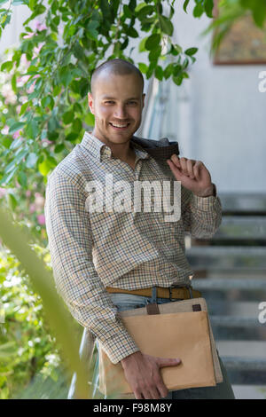 Gut aussehend zuversichtlich Geschäftsmann Porträt auf Treppen mit Unterlagen Stockfoto