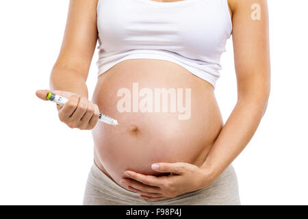 Nicht erkennbare schwangere Frau mit Spritze in der Hand, isoliert auf weiss, isoliert auf weißem Hintergrund Stockfoto