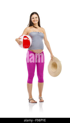 Schöne schwangere Frau in Sommerkleidung, Strohhut und Ball bereit, gehen Sie zum Strand, isoliert auf weiss Stockfoto