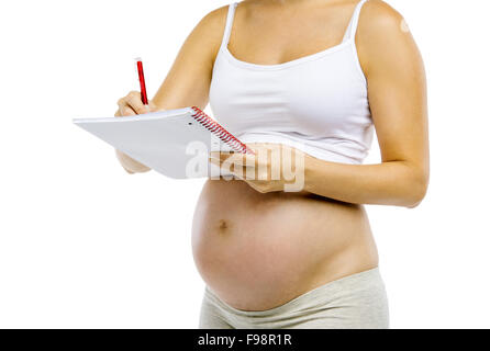 Studio-Porträt einer unkenntlich Schwangeren mit Notizbuch und Stift isoliert auf weißem Hintergrund Stockfoto