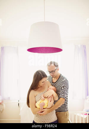 Glückliche junge Eltern mit ihren neugeborenen Mädchen zu Hause Stockfoto