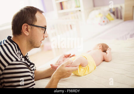 Glückliche junge Vater genießen Sie besondere Momente mit seiner neugeborenen Tochter zu Hause Stockfoto