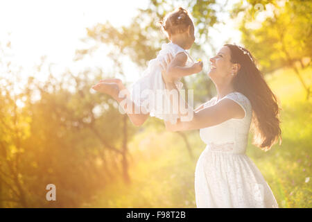 Glückliche junge schwangere Mutter und ihre kleine Tochter viel Spaß im Sommer-Natur Stockfoto