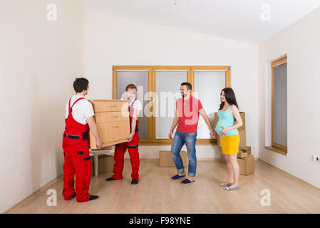 Umzugsunternehmen in neues Haus mit jungen Familie Stockfoto