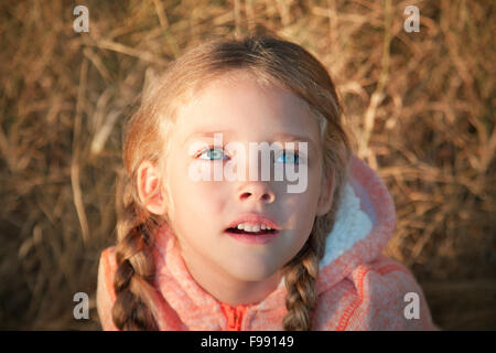 Porträt von einem kleinen Mädchen mit blauen Augen und Zöpfen Stockfoto