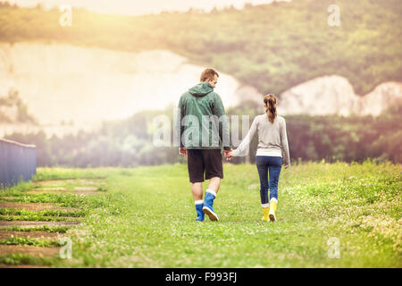 Junges Paar in bunte Gummistiefel Wandern in schlammigen Natur. Stockfoto