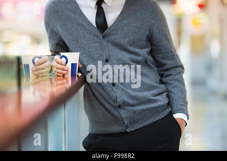 Hübscher junger Mann im Einkaufszentrum Kaffeetrinken Stockfoto
