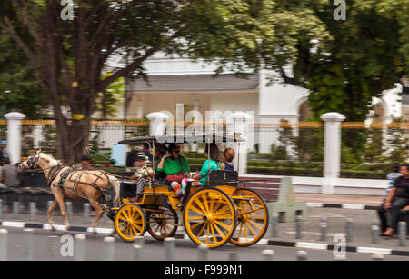 YOGJAKARTA, Indonesien - 21. August 2015: panning Shot von Touristen, die Fahrt in einer Pferdekutsche in den Straßen von Yogyakarta. Stockfoto