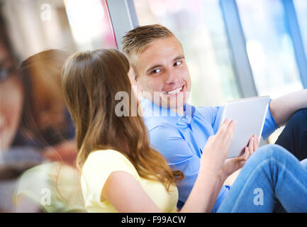 Lächelnde Paare, die Spaß mit digital-Tablette im Einkaufszentrum Stockfoto