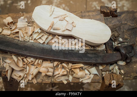 Ein Manometer neben einem Holzschuh Bett am Arbeitsplatz des Clog Makers Manfred Karolczak in der Spreewald-Gemeinde Burg (Brandenburg), Deutschland, 07. Dezember 2015. Seit 1909 haben in dem kleinen Familienbetrieb handgefertigten Holzschuhe aus Pappel und Erle Holz geschnitzt worden. Die Holzplatte ist mit Schweinsleder überzogen und mit Draht geklemmt. Nach etwa einer Stunde ein Paar Holzschuhe gemacht. Die Schuhe eignen sich besonders für den Garten und sind relativ unempfindlich gegenüber Feuchtigkeit aufgrund der Naturmaterialien. Foto: Patrick Pleul/dpa Stockfoto