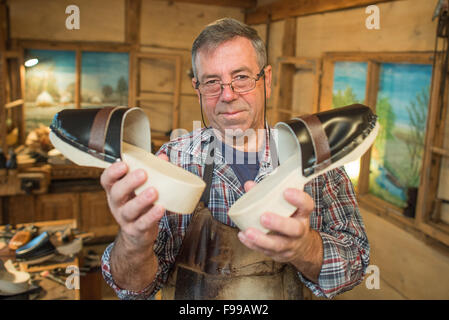 Clog-Hersteller zeigt Manfred Karolczak fertigen clogs an seinem Arbeitsplatz in der Spreewald-Gemeinde Burg (Brandenburg), Deutschland, 07. Dezember 2015. Seit 1909 haben in dem kleinen Familienbetrieb handgefertigten Holzschuhe aus Pappel und Erle Holz geschnitzt worden. Die Holzplatte ist mit Schweinsleder überzogen und mit Draht geklemmt. Nach etwa einer Stunde ein Paar Holzschuhe gemacht. Die Schuhe eignen sich besonders für den Garten und sind relativ unempfindlich gegenüber Feuchtigkeit aufgrund der Naturmaterialien. Foto: Patrick Pleul/dpa Stockfoto