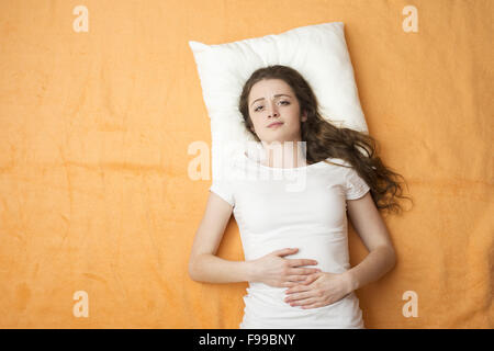 Kranke Frau liegt auf dem Bett. Stockfoto