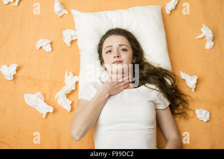 Kranke Frau im Bett mit Halsschmerzen. Sie hat Erkältung und Grippe. Stockfoto