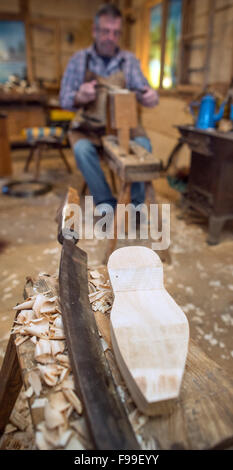 Ein Manometer neben einem Holzschuh Bett am Arbeitsplatz des Clog Makers Manfred Karolczak in der Spreewald-Gemeinde Burg (Brandenburg), Deutschland, 07. Dezember 2015. Seit 1909 haben in dem kleinen Familienbetrieb handgefertigten Holzschuhe aus Pappel und Erle Holz geschnitzt worden. Die Holzplatte ist mit Schweinsleder überzogen und mit Draht geklemmt. Nach etwa einer Stunde ein Paar Holzschuhe gemacht. Die Schuhe eignen sich besonders für den Garten und sind relativ unempfindlich gegenüber Feuchtigkeit aufgrund der Naturmaterialien. Foto: Patrick Pleul/dpa Stockfoto