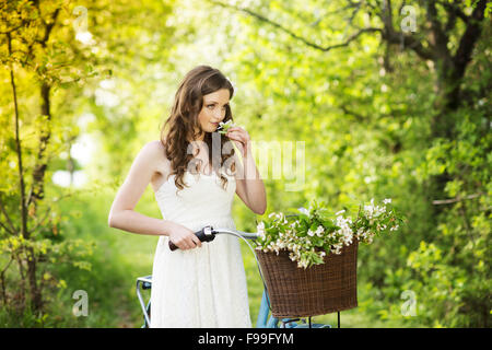 Hübsche junge Frau mit Retro-Motorrad im grünen park Stockfoto