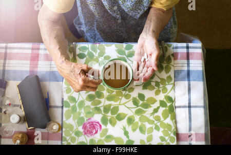 Nahaufnahme des alten Weibes Hände halten Pillen in Küche Küche Stockfoto