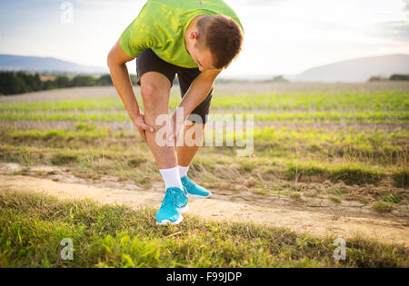 Läufer Bein und Muskel Schmerzen beim Lauftraining im Freien im Sommer-Natur Stockfoto