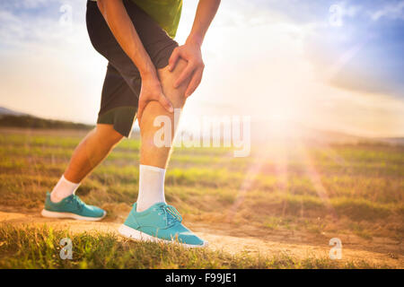 Läufer Bein und Muskel Schmerzen beim Lauftraining im Freien im Sommer-Natur Stockfoto