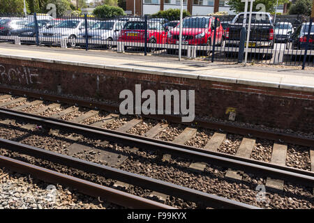 Eisenbahnschienen und Parkplatz im Hintergrund, Surrey, UK Stockfoto