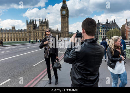 Junger Mann die Fotos von attraktiven weiblichen vor House of Parliament, London, UK Stockfoto