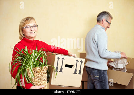 Zwei glückliche ältere Leute mit vielen Umzugskartons Stockfoto