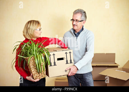 Zwei glückliche ältere Leute mit vielen Umzugskartons Stockfoto