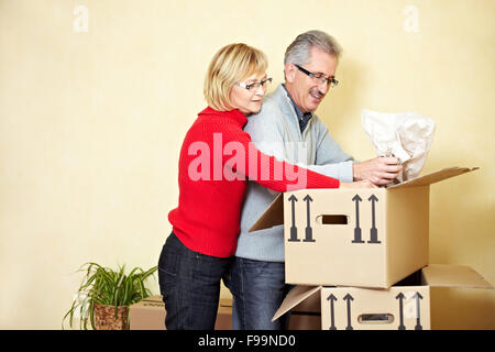 Zwei ältere Leute, die Sachen in einem Umzugskarton suchen Stockfoto