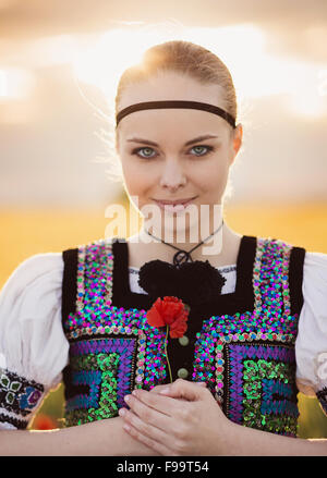 Schöne Frau im Feld. Sie ist Osteuropa Trachten tragen. Stockfoto