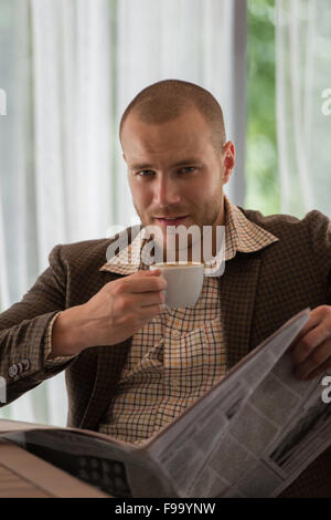 Nachdenklich Geschäftsmann im Café eine Zeitung lesen Stockfoto