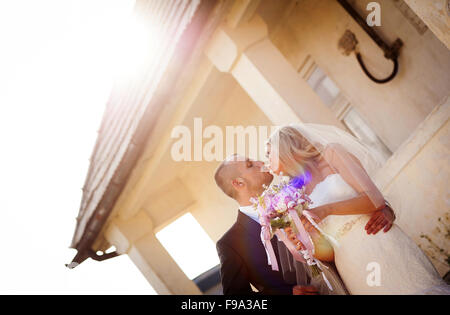 Glückliche Braut und Bräutigam posieren durch das alte Haus Stockfoto