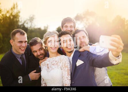 Outdoor Portrait schöne junge Braut mit Bräutigam und seine Freunde nehmen selfie Stockfoto