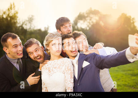 Outdoor Portrait schöne junge Braut mit Bräutigam und seine Freunde nehmen selfie Stockfoto