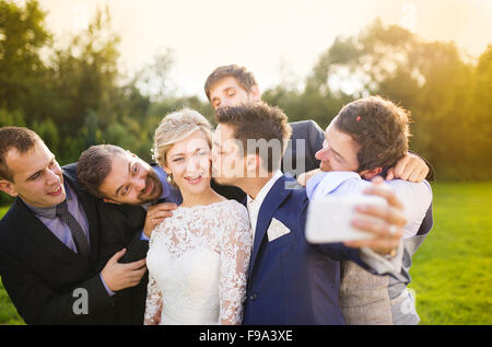 Outdoor Portrait schöne junge Braut mit Bräutigam und seine Freunde nehmen selfie Stockfoto