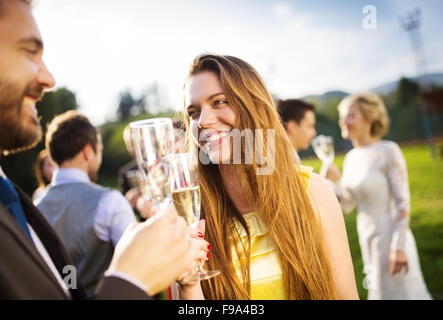 Hochzeitsgäste Klirren der Gläser bei der Hochzeitsfeier außerhalb Stockfoto