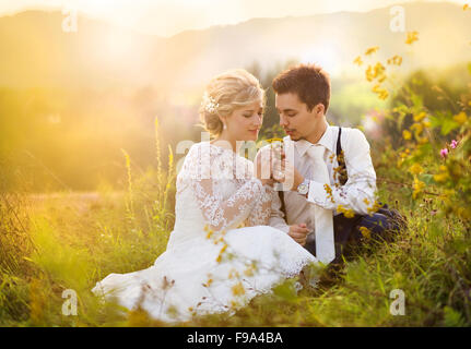 Genießen Sie romantische Momente auf einer Wiese, Sommer-Natur im Freien sitzen junge Hochzeitspaar Stockfoto