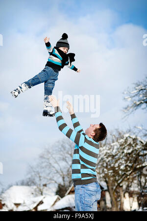 Glücklicher Vater mit Sohn Spaß draußen im Schnee Stockfoto