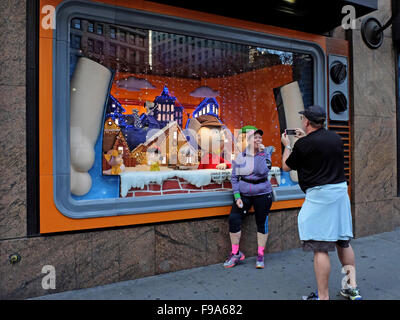 Touristen-Pose für ein lustiges Foto vor a Charlie Brown Christmas Fenster bei Macy's Herald Square, New York City. Stockfoto