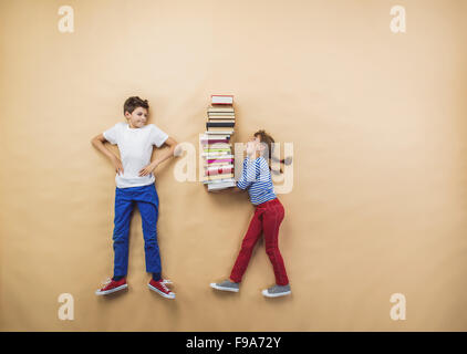 Glückliche Kinder, die spielen mit Gruppe von Büchern im studio Stockfoto