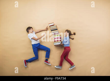 Glückliche Kinder, die spielen mit Gruppe von Büchern im studio Stockfoto