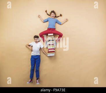 Glückliche Kinder, die spielen mit Gruppe von Büchern im studio Stockfoto