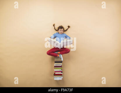 Glückliches Mädchen spielt mit Gruppe von Büchern im studio Stockfoto