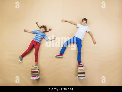 Glückliche Kinder, die spielen mit Gruppe von Büchern im studio Stockfoto