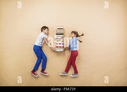 Glückliche Kinder, die spielen mit Gruppe von Büchern im studio Stockfoto