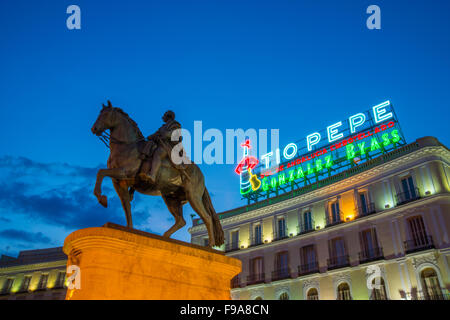 Tio Pepe Neon Schild an seinen neuen Standort und Carlos III Statue, Nachtansicht. Puerta del Sol, Madrid, Spanien. Stockfoto