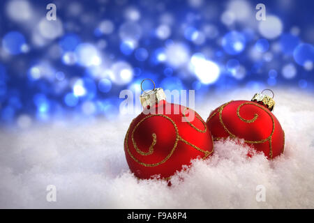 Weihnachten Urlaub Kunde Grußkarte Hintergrund mit Schnee, roten Kugeln und blaue Bokeh-Effekt. Stockfoto