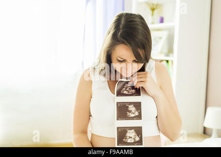 Schöne schwangere Frau mit Ultraschall Scan Bild Stockfoto