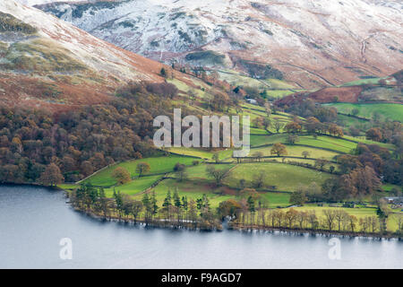 Eine Landschaftsansicht unten in Ullswater und umliegende Farmland in der Lake District Cumbria UK im Winter mit Schnee bedeckten mountai Stockfoto