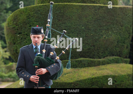 Teen Junge draußen Crathes Castle in Aberdeenshire, Schottland Dudelsack spielen. Stockfoto